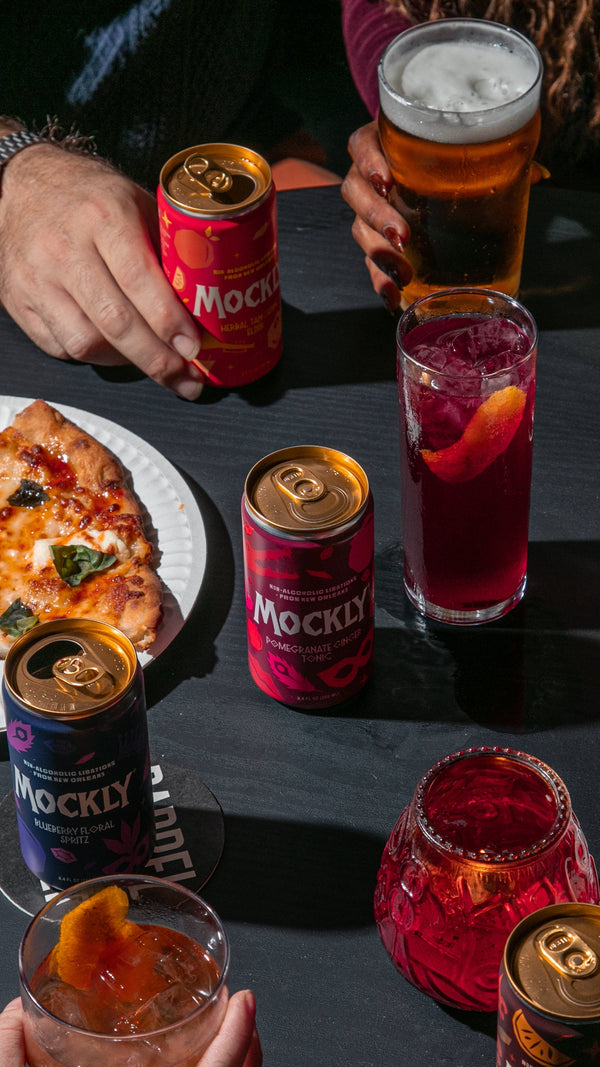 People enjoying pizza and drinks at a table with Mocky mocktails.